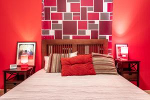 a bedroom with a bed with a red wall at Flatguest Ingenio + 2 Bdr + Wifi + 4PAX in Ingenio
