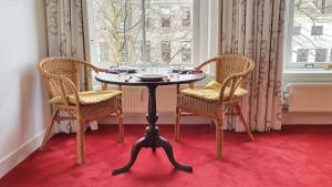 ユトレヒトにあるLarge Historical Apartment & Canal Terraceのテーブル(椅子2脚、ガラス付)