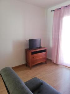 ein Wohnzimmer mit einem Sofa und einem TV auf einer Kommode in der Unterkunft Apartamento Naturista en primera línea en Natura World! in Vera + 27 Fotos