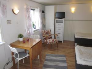 Habitación pequeña con mesa y dormitorio en Huldas Gård en Kumla