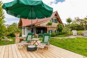 a patio with two chairs and a table with an umbrella at Ferienhaus Höllberg in Hörmsdorf