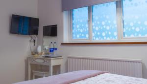 um quarto com uma cama, uma janela e uma mesa em Blyth Lodge B&B em Halesworth