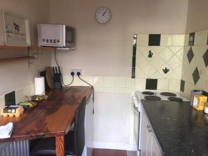 a kitchen with a sink, stove, microwave and refrigerator at Redington House SelfCatering accommodation in Cobh