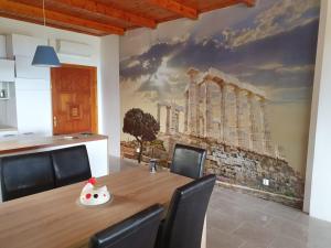 a dining room with a table and a painting on the wall at Willa wakacyjna z basenem w Eretria in Eretria