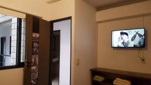 a room with a television on the wall with a bathroom at Hostel Carlos Gardel in Buenos Aires