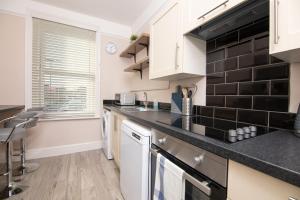 a kitchen with white cabinets and a black counter top at Salt Lane Apartments in Salisbury
