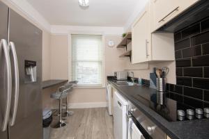 uma cozinha com armários brancos e um frigorífico preto em Salt Lane Apartments em Salisbury