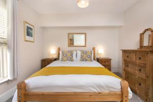 1 dormitorio con 1 cama grande con manta amarilla en Salt Lane Apartments, en Salisbury