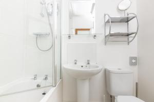Baño blanco con lavabo y aseo en Salt Lane Apartments, en Salisbury