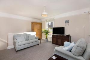 a living room with two chairs and a flat screen tv at Salt Lane Apartments in Salisbury