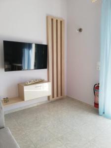 a living room with a flat screen tv on a wall at Aloni Studios and Apartments in Lassi