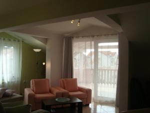 a living room with two chairs and a large window at Apartments Eja in Zadar