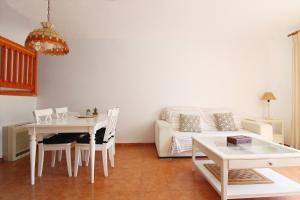 a living room with a table and a couch at Global Properties, Adosado en la playa con piscina in Sagunto