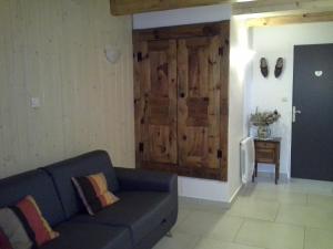 ein Wohnzimmer mit einem blauen Sofa und einer Tür in der Unterkunft La Pause auvergnate in Le Bouchet-Saint-Nicolas