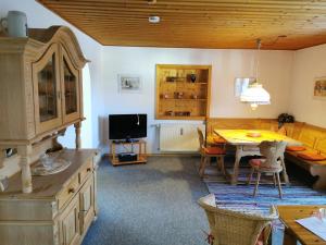 a dining room with a table and a tv at Haus Haidweg - Ferienwohnungen in Haidmühle im Dreiländereck DE-CZ-AT in Haidmühle