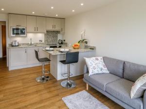 a living room with a couch and a kitchen at 1 Barn Cottages in Halifax