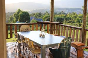 a table and chairs on a deck with a view at Round Here Self-Catering Holiday Home in Sabie