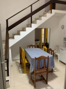 comedor con mesa, sillas y escaleras en Casa Morro de São Paulo, en Morro de São Paulo