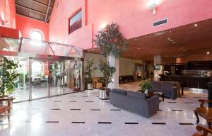un hall avec des canapés et des plantes dans un bâtiment dans l'établissement Hotel San Juan de los Reyes, à Tolède