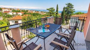 a table on a balcony with chairs and a bowl of fruit at Rona apartments Smokva in Rijeka