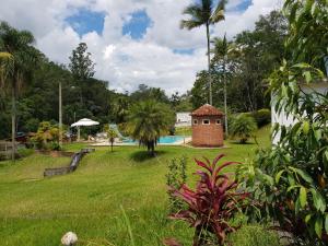 une cour avec une piscine et une maison dans l'établissement Sítio Zen 37 hectares de flora e fauna preservadas, a 50" da Capital, com wifi 30mbps!, à Mogi das Cruzes