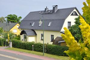 a large white house with a black roof at Ferienwohnung Glasperlenfloh in Ilmenau