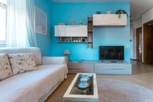 un soggiorno con divano bianco e TV di Porto Azzurro Apartment a Varenna