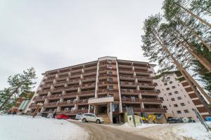 Un gran edificio con un coche aparcado delante. en Apartment Victory in Vila Pekovic, en Zlatibor