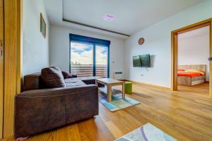 una sala de estar con un sofá y una cama en Apartment Victory in Vila Pekovic, en Zlatibor