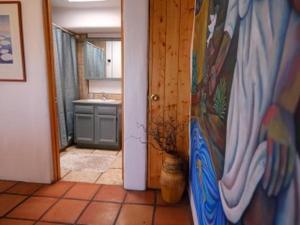 Casas de Guadalupe - Sante Fe Vacation Rentals في سانتا فيه: حمام مع مغسلة وباب مع لوحة