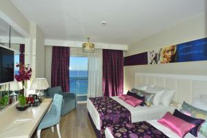 a hotel room with a bed and a desk at Azura Deluxe Resort & Spa - Ultra All Inclusive in Avsallar