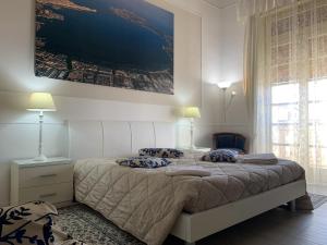 Casa di Alice Luxury Hospitality - Elevator, Fast WiFi في سيراكوزا: غرفة نوم بسرير كبير عليها لوحة على الحائط