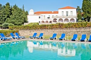 a row of blue lounge chairs next to a swimming pool at Lam Hotel Convento do Desagravo in Oliveira do Hospital
