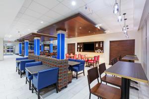 a dining room with blue tables and chairs at Holiday Inn Express & Suites Tulsa South - Woodland Hills, an IHG Hotel in Tulsa
