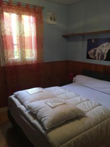 a bedroom with two beds and two windows at Gîte Espace et Montagne in Aragnouet