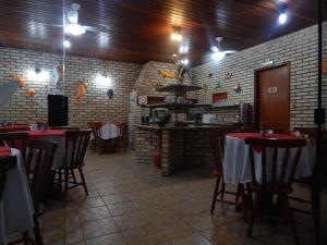 uma sala de jantar com mesas e cadeiras e paredes de tijolos em Pousada Salines em Florianópolis