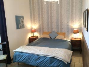 a bedroom with a bed with two lamps and a chandelier at La Banne Nord in Cendrieux