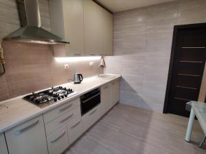 uma cozinha com um fogão e um lavatório em Сучасна квартира em Lutsʼk