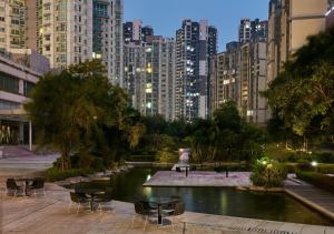 a park with chairs and a pond in a city at Crowne Plaza Zhongshan Wing On City by IHG in Zhongshan