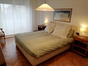 a bedroom with a large bed with two tables and two lamps at Casa Pinturicchio in Rome