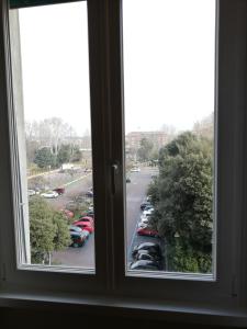 una ventana con vistas a un aparcamiento con coches aparcados en Casa Pinturicchio, en Roma