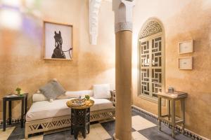 - un salon avec un canapé et une table dans l'établissement Riad Hissan, à Marrakech