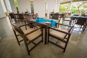 una sala da pranzo con tavolo e sedie in legno di Roman Beach Hotel a Hikkaduwa