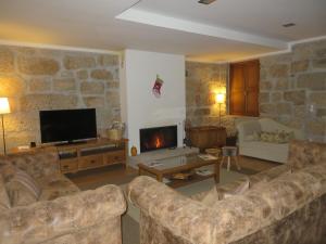a living room with two couches and a fireplace at Quinta do Palame in Vila Flor
