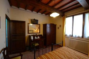 a bedroom with a bed and a dresser and a window at Agriturismo La Casella in Castelfranco di Sopra