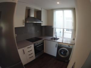 una pequeña cocina con fregadero y lavadora en Coqueto apartamento de 2 habitaciones en zona estación tren, en A Coruña