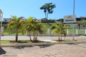 a group of palm trees in front of a fence at Vale do Sol Pousada Hotel in São José do Rio Pardo