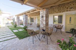 a patio with chairs and a table on a building at Acrothea Perdika in Perdika