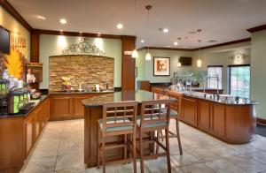 a large kitchen with a bar with stools at Staybridge Suites Omaha 80th and Dodge, an IHG Hotel in Omaha