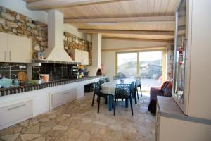 a kitchen with a table and chairs in a room at Acrothea Perdika in Perdika
